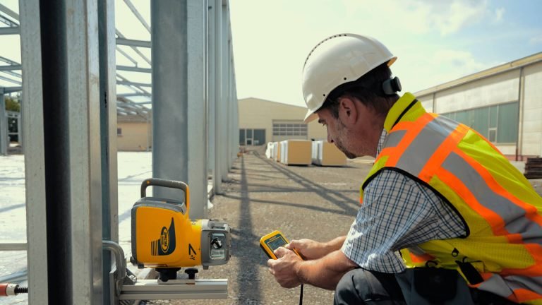 Construction technology supporting accurate site layout with digital surveying equipment on a commercial construction project.