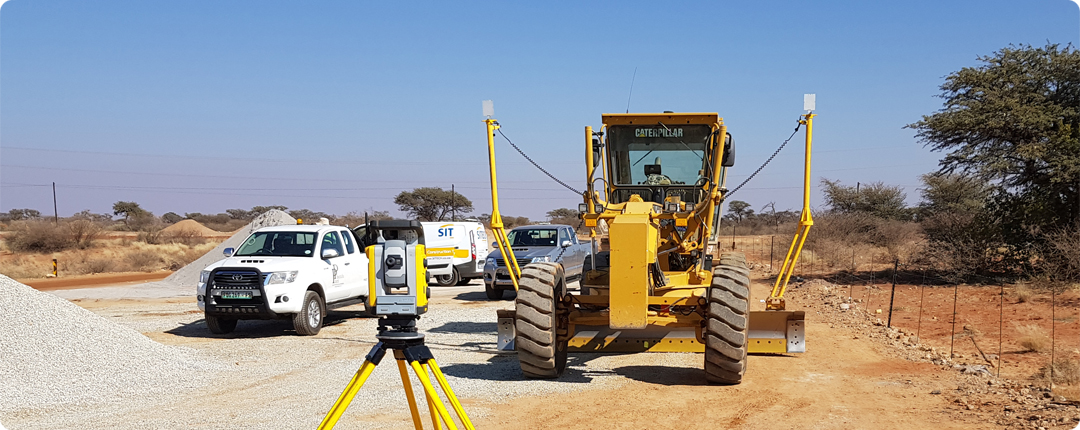 s_support-2 Motor grader on a road construction site using Trimble Earthworks technology for precise grading and excavation.