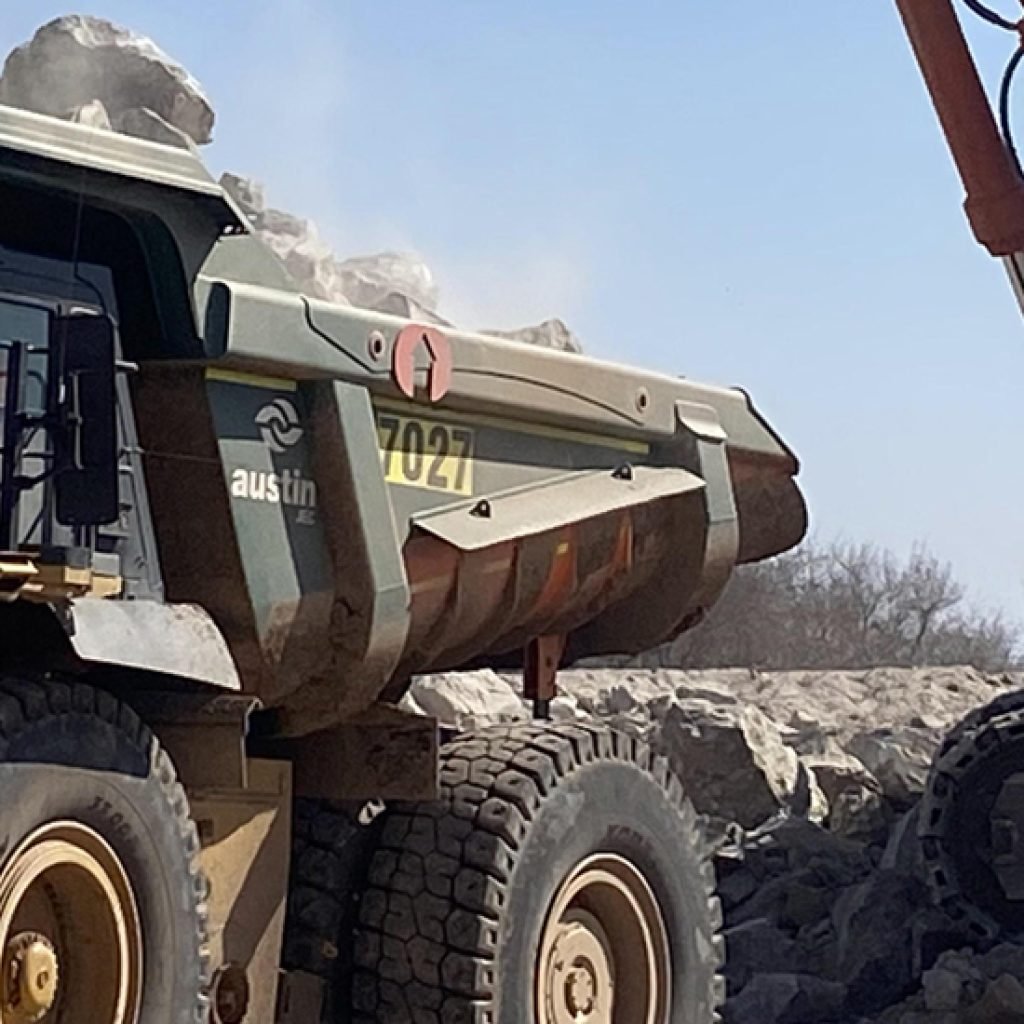 Haul truck being loaded by an excavator at a mining site, showcasing Loadrite fleet insights for real-time payload monitoring and fleet performance.